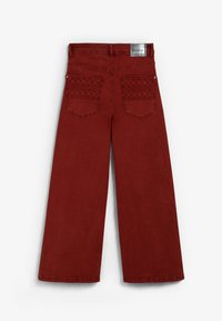 Jeans rojos de pierna ancha con bolsillos traseros bordados y una etiqueta de marca plateada en la cintura, mostrados desde atrás sobre un fondo blanco.