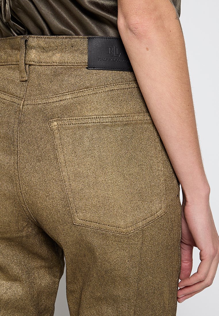Spodnie dżinsowe w kolorze brązowym mają naszywkę z sztucznej skóry z logo "Ralph Lauren". Tylny kieszeń ma prostokątny kształt z widocznym przeszyciem.