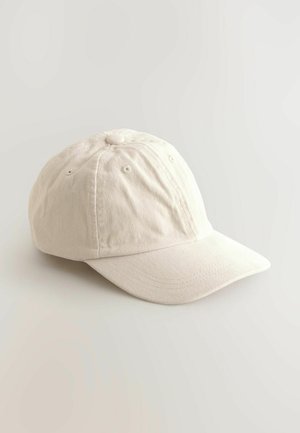 Gorra de algodón de color beige claro con visera curva, estructura de seis paneles, ojales de ventilación y parte superior redondeada. Textura suave.