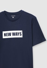 Granatowy bawełniany t-shirt z okrągłym dekoltem, z białym prostokątnym nadrukiem z napisem "NEW WAYS" w pogrubionych czarnych literach.
