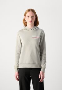 Sudadera gris claro con bolsillo frontal, capucha con cordón y logo de GANT 1949 en blanco y rojo. El material parece texturizado y suave.