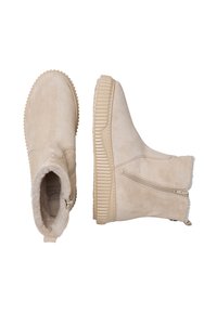Botas de tobillo de ante beige con una suela de goma texturizada y estriada, y un suave forro de piel, que cuentan con una cremallera lateral para facilitar su uso.
