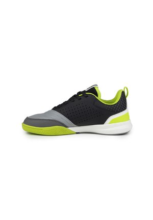 Zapatilla deportiva negra y gris con acentos en verde neón. Presenta un diseño perforado, materiales texturizados y una suela de goma.