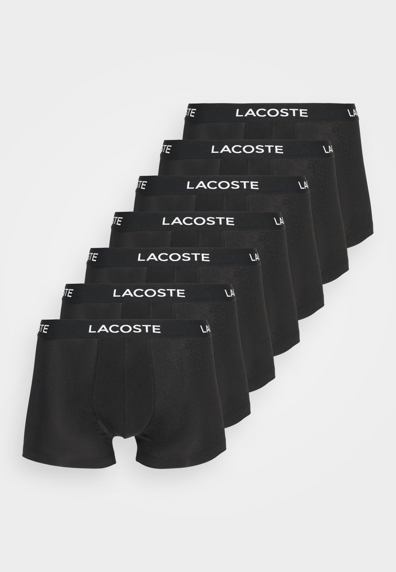 Boxer in cotone neri disposti in fila, caratterizzati da un tessuto morbido ed elastico, con il logo bianco "LACOSTE" sulla vita.