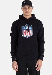 Felpa con cappuccio nera con logo NFL, caratterizzata da accenti rossi, blu e bianchi. Tessuto morbido, tasca frontale a marsupio e polsini a coste.