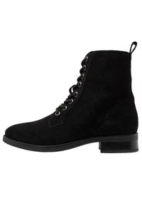 Stivale demi in suede nero con punta rotonda, design con lacci, hardware argento e tacco basso a blocco. Presenta un linguetta sul retro.