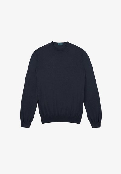 Granatowy sweter robiony na drutach, z długimi rękawami, okrągłym dekoltem oraz ściągaczami przy mankietach i u dołu. Wykonany z miękkiego materiału o gładkiej fakturze.