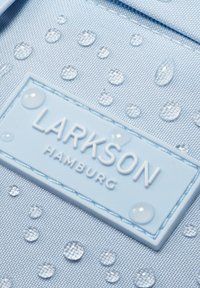 Világoskék, texturált szövet vízcseppekkel, a sarkán egy fehér, dombornyomott "LARKSON HAMBURG" címkével.