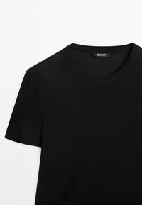Sort t-shirt med korte ærmer, rund halsudskæring og glat stoftekstur. Har en label med "Massimo Dutti" inde i kraven.
