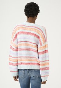 Pull rayé dans des teintes pastel d'orange, de rose et de lavande, avec une coupe décontractée et des bords côtelés. Tissu doux et texturé.