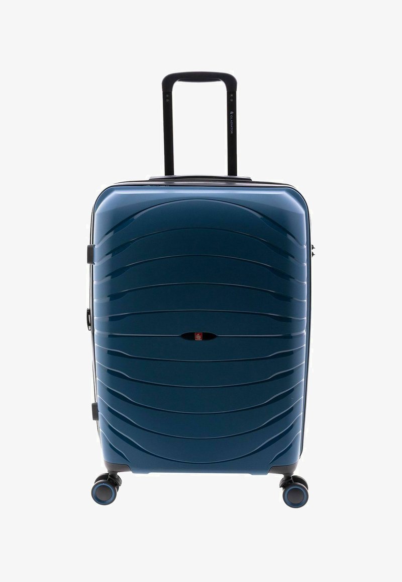 Maleta rígida de color azul oscuro con superficie con patrón de olas, asa retráctil y cuatro ruedas multidireccionales para facilitar la movilidad.