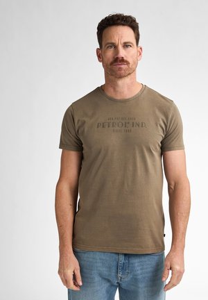 Olive green cotton t-shirt with short sleeves, round neckline, and front graphic print featuring "PETROL IND. SINCE 1939." in dark lettering.