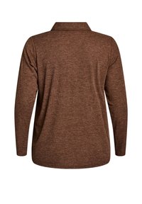 Brown long-sleeve polo shirt with a collar, made from ribbed fabric, featuring a loose fit and a straight hem at the bottom.