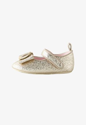 Zapato Mary Jane dorado texturizado para niñas con correa y lazo decorativo en la punta, forro interior rosa y tirador en el talón.