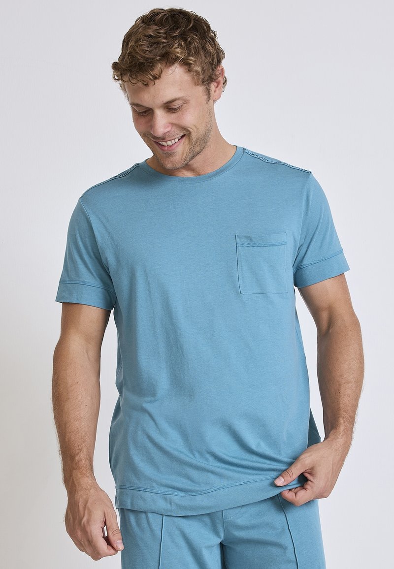 Light blue cotton t-shirt with a round neckline, short sleeves, and a chest pocket. Features contrast stitching on the shoulders.