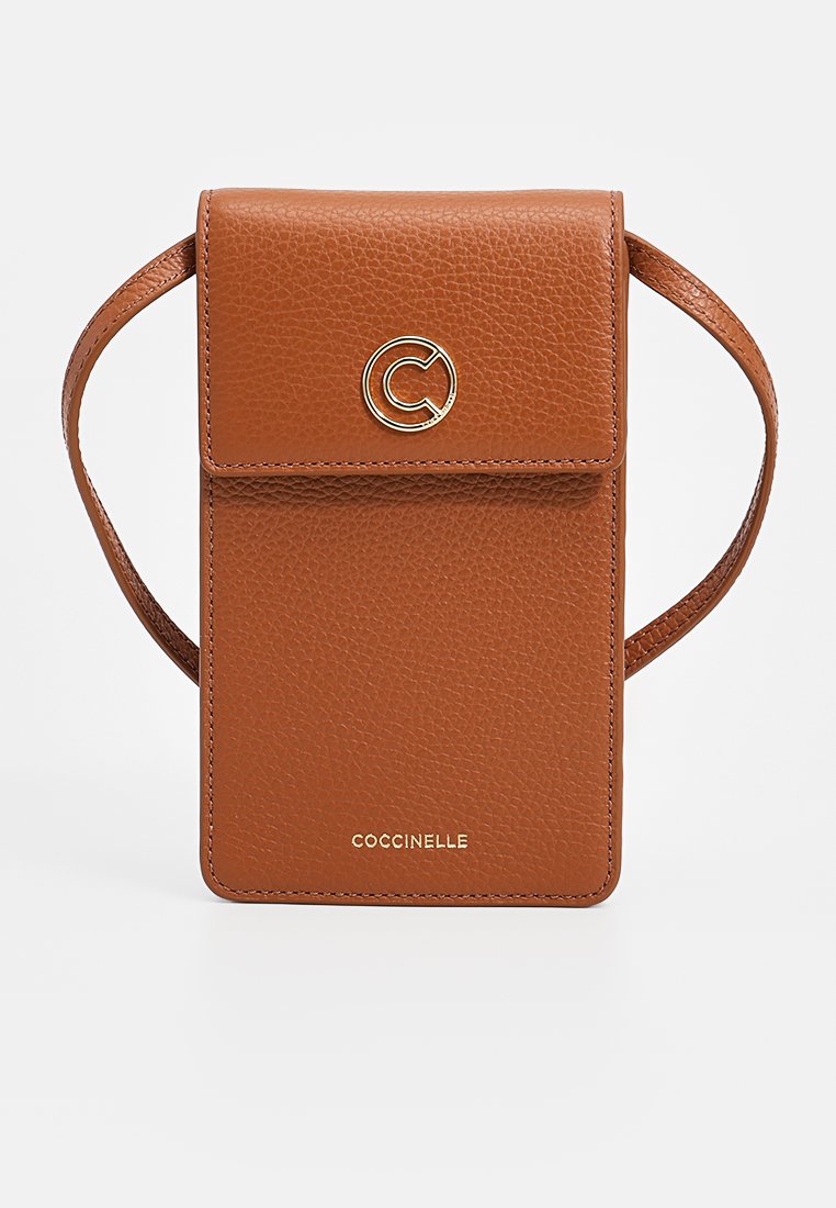 Skórzana torba na ramię w kolorze brązowym z klapką, złotymi elementami, wytłoczonym logo i teksturowanym wykończeniem. W zestawie regulowany pasek.