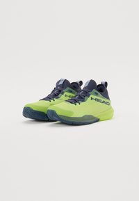 Baskets de sport Head en vert lime et bleu marine. Tige en maille avec une semelle texturée, arborant le logo de manière proéminente sur le côté.