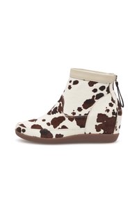 Sleehak enkellaarsje in wit en bruin koeienprint, gemaakt van leer en stof, met een ritssluiting en een slank silhouet.