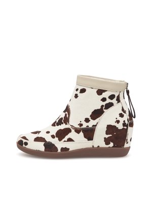 Bottine compensée à imprimé vache blanc et marron, en cuir et tissu, avec fermeture éclair et silhouette élégante.