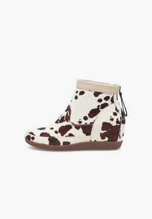 Bottine compensée à imprimé vache blanc et marron, en cuir et tissu, avec fermeture éclair et silhouette élégante.