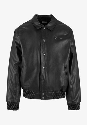 Schwarze Lederjacke mit einem Kragen, Druckknöpfen, Seitentaschen sowie elastischen Rippbündchen am Saum und an den Ärmeln. Verfügt über ein dezentes Logo.