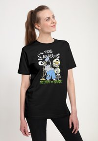Camiseta negra con un gráfico de "Los Simpson" que incluye personajes de dibujos animados, esqueletos y el texto "Treehouse of Horror" en verde.