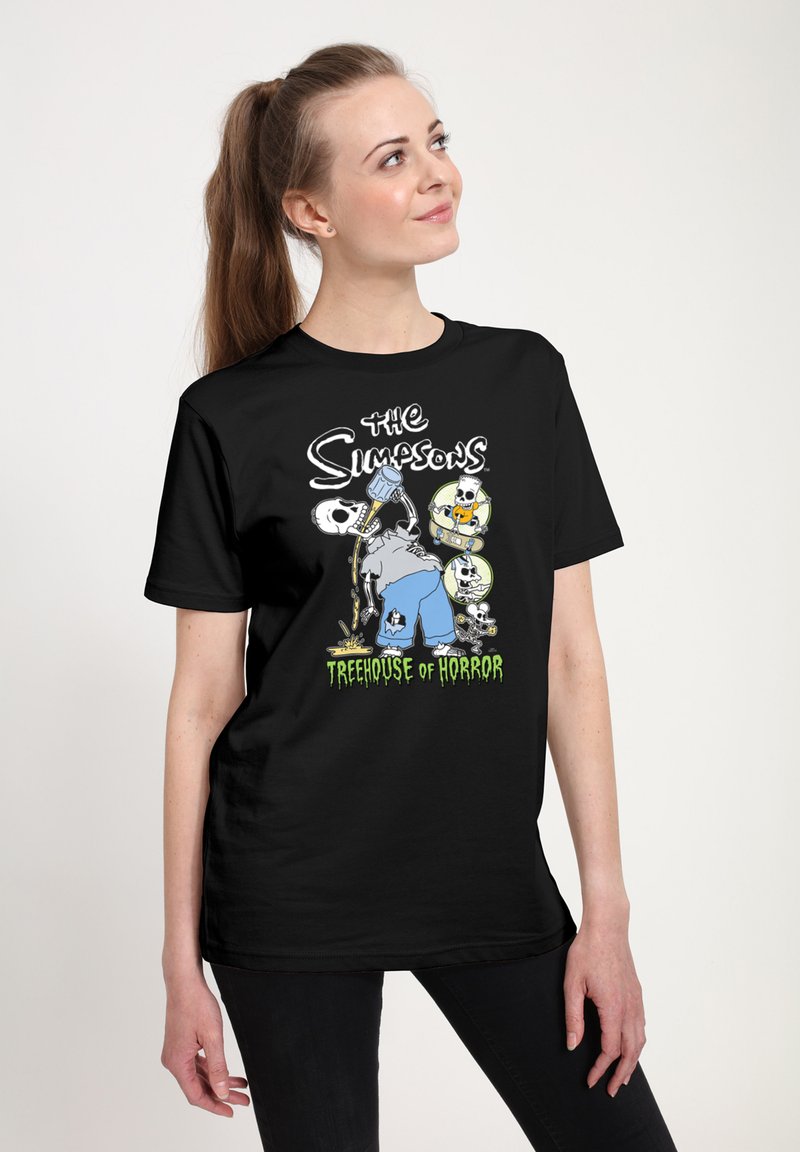 Camiseta negra con un gráfico de "Los Simpson" que incluye personajes de dibujos animados, esqueletos y el texto "Treehouse of Horror" en verde.