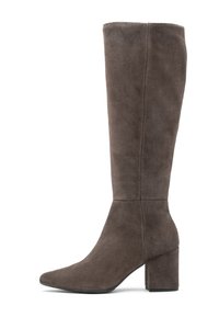 Stivale alto in suede marrone, con punta affusolata, tacco a blocco e design senza cuciture. Presenta cuciture sottili lungo il lato per un tocco di dettaglio.