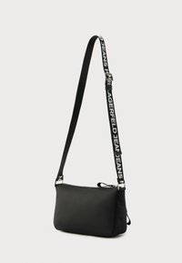 Μαύρη τσάντα ώμου από μαλακό υλικό, με κλείσιμο με φερμουάρ, ρυθμιζόμενο λουρί με κείμενο «Lagerfeld Jeans» και μεταλλικές λεπτομέρειες.