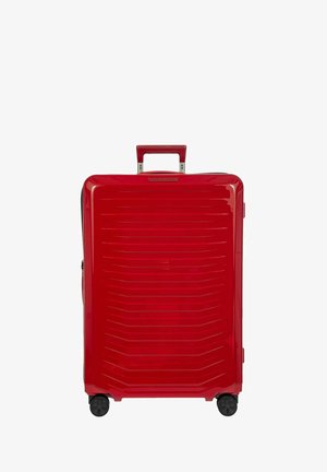 Maleta dura roja con un acabado brillante, patrón de líneas horizontales, mango extensible y cuatro ruedas giratorias para una fácil maniobrabilidad.