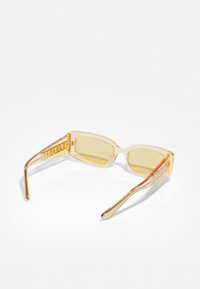 Clear frame sunglasses with yellow-tinted lenses, rectangular shape, and logo detail on the sides. Textured arms with subtle accents.