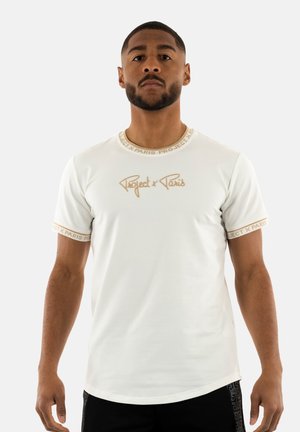 Camiseta blanca de manga corta con cuello redondo, logo bordado "Project x Paris" en dorado y ribete dorado contrastante en las mangas.