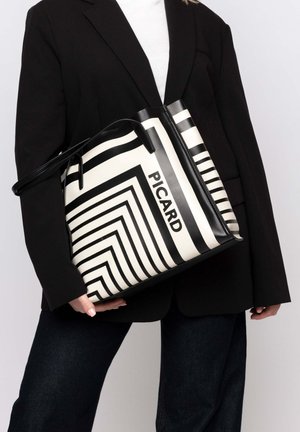 Schwarz-weiße Streifen-Eimer-Tasche mit glänzender Oberfläche, auf der das Wort "PICARD" deutlich hervorgehoben ist. Lange schwarze Schultergurt inklusive.