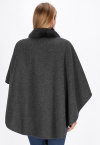 Poncho din amestec de lână gri închis, cu guler din blană artificială, croială largă și textură netedă, având un decolteu deschis și o margine rotunjită.