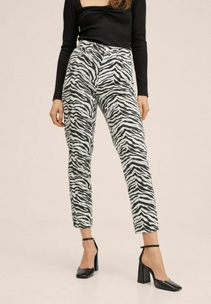 Zwart-witte zebraprint broek met een hoge taille, taps toelopende pasvorm en een gladde textuur, gestyled met zwarte pumps met vierkante neus.