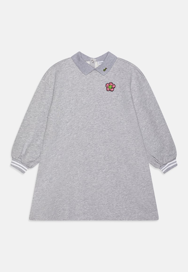 Robe grise à manches longues avec des poignets côtelés, un col gris foncé avec un petit logo vert et un patch fleur rose sur la poitrine.