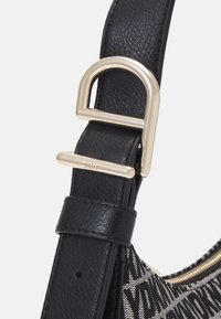 Czarny pasek ze skóry z klamrą i okuciami w kolorze złotym, o fakturowanym wykończeniu. Projekt zawiera detal z wzorzystej tkaniny.