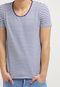 T-Shirt mit kurzen Ärmeln aus weichem Stoff, mit horizontalen navyblauen und weißen Streifen, einem runden Halsausschnitt und einem lockeren Schnitt.