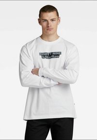 Biely dlhý rukáv s výraznou čiernou grafikou "EIGHTY NINE G-Star Raw" uprostred, s okrúhlym výstrihom a voľným strihom.