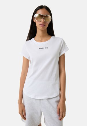Witte katoenen T-shirt met opgerolde mouwen, met een zwarte "FIRE+ICE" opdruk op de voorkant. Vergezeld van oversized, reflecterende zonnebril.