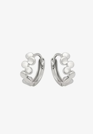 Boucles d'oreilles en argent présentant un design distinctif avec des accents circulaires superposés, une finition lisse et une texture polie.