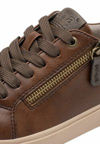Baskets en cuir marron avec lacets marrons, dotées d'une fermeture éclair sur le côté et d'une couture d'accent. Semelle en caoutchouc de couleur crème. Dessus texturé.