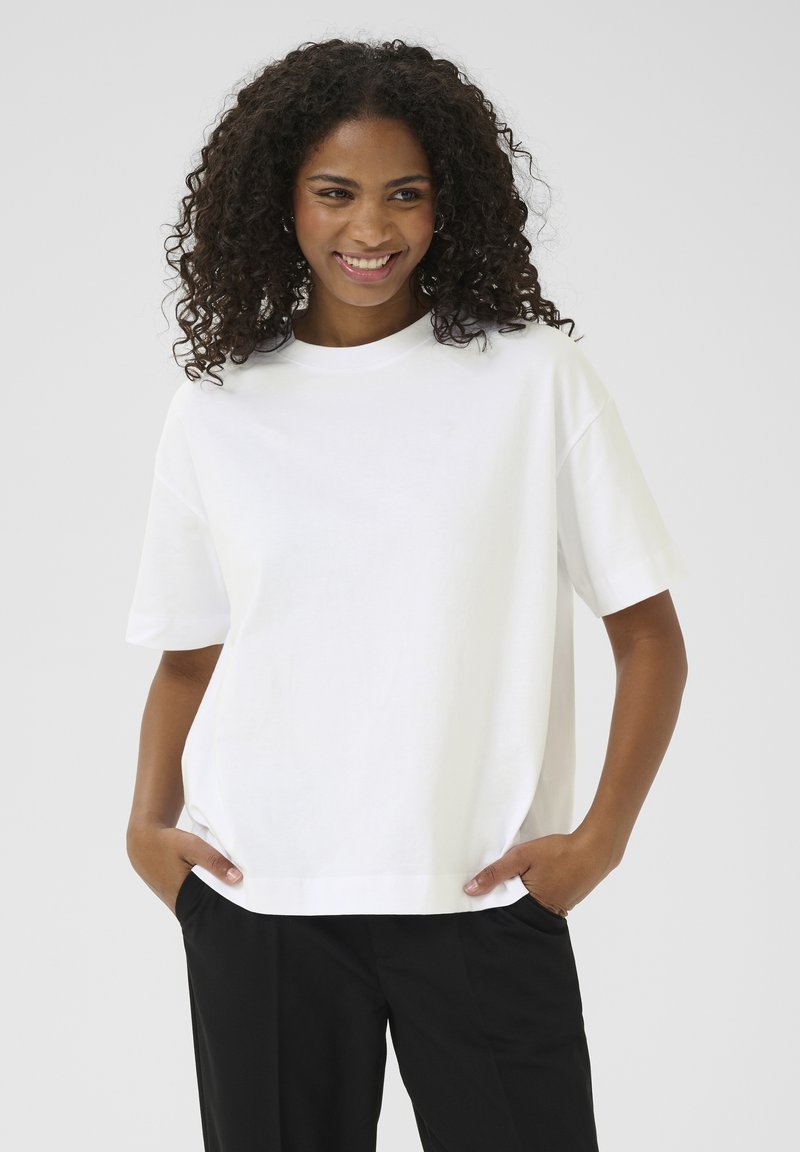 Witte katoenen T-shirt met een ronde hals, korte mouwen en een relaxte pasvorm; heeft zijzakken en een soepele textuur.