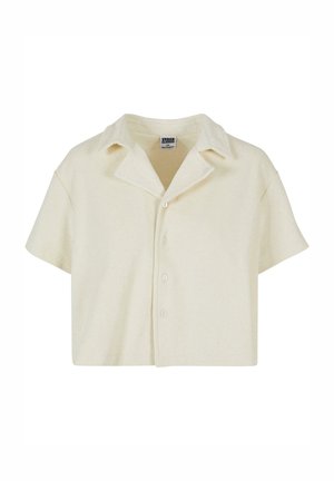 Korte mouwen, kortshirt gemaakt van zachte, beige stof. Heeft een puntige kraag en vijf knopen aan de voorkant. Gestructureerd oppervlak.