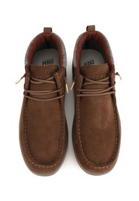 Chaussures en suede marron avec un bout arrondi, doublure de chaussette grise contrastante et couture décorative ; elles possèdent des lacets marron et une languette à l'arrière.