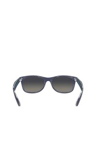 Occhiali da sole con lenti a gradiente grigio scuro, montatura in plastica blu navy e aste trasparenti. Forma rotonda con logo discreto sul lato.