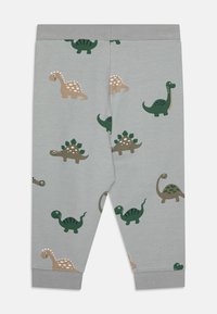 Leggings grigi con vari stampati di dinosauri in verde, marrone e crema. Tessuto di cotone morbido con vita elastica e polsini a coste.