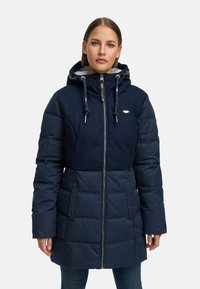 Giacca a vento navy con cappuccio, pannelli testurizzati, chiusura con zip e dettagli con cordino. Presenta tasche laterali e lunghezza fino a metà coscia.