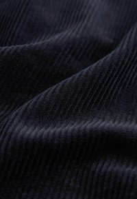 Țesătură de corduroy de culoare bleumarin închis, cu o textură striată, prezentând dungi verticale și un aspect moale și pufos. Ideală pentru tapițerie sau îmbrăcăminte.