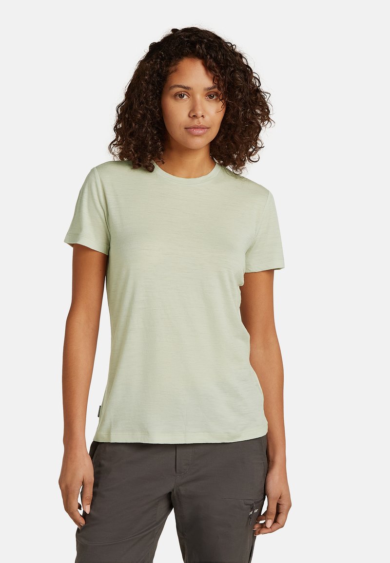 Helles grünes T-Shirt mit kurzen Ärmeln und rundem Halsausschnitt, glatter Textur und lässiger Passform. Etikett auf der linken Seite nah dem Saum sichtbar.